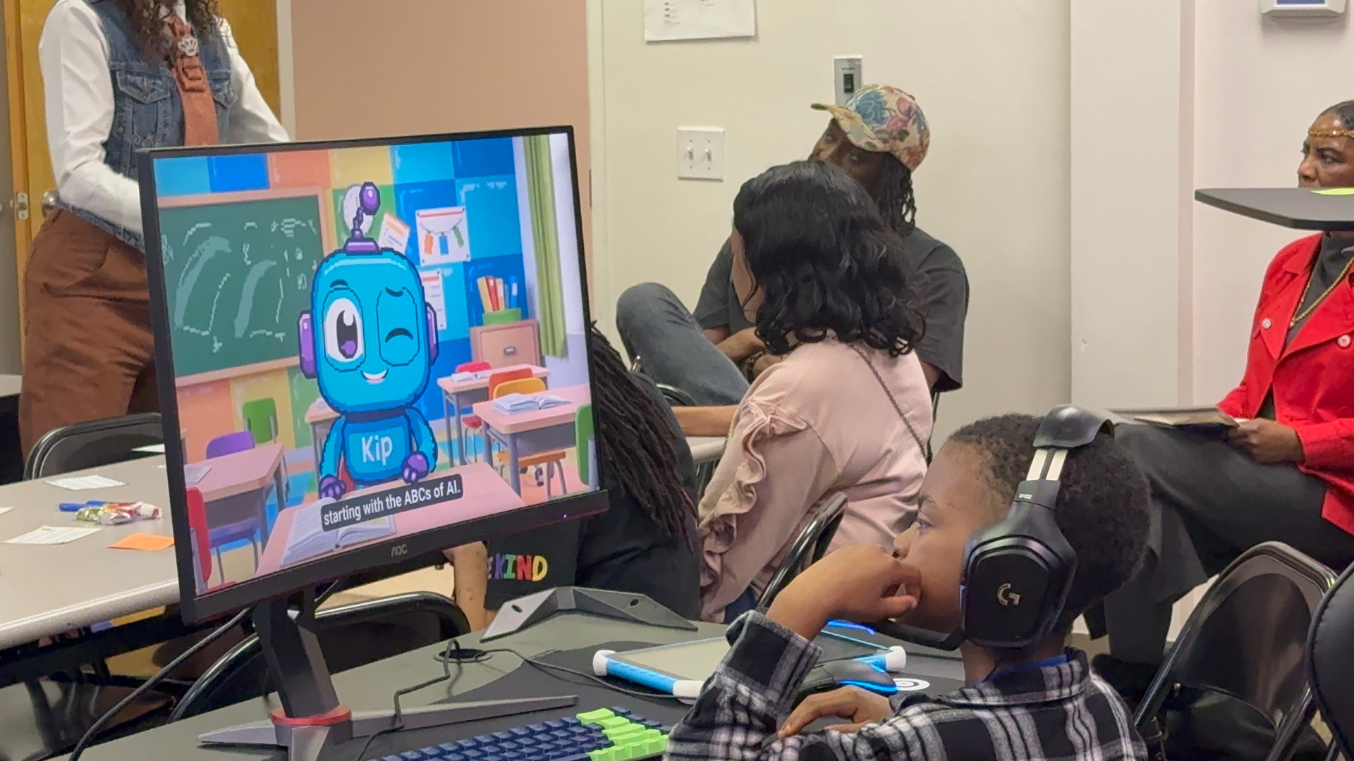 A young learner with headphones meets Kip the robot during a KidoTech AI literacy session